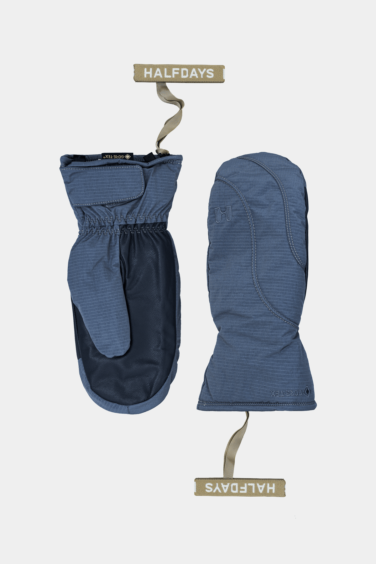A pair of Halfdays winter mittens in a dusty blue and navy colorway, shown flat against a light gray background with brand tags.