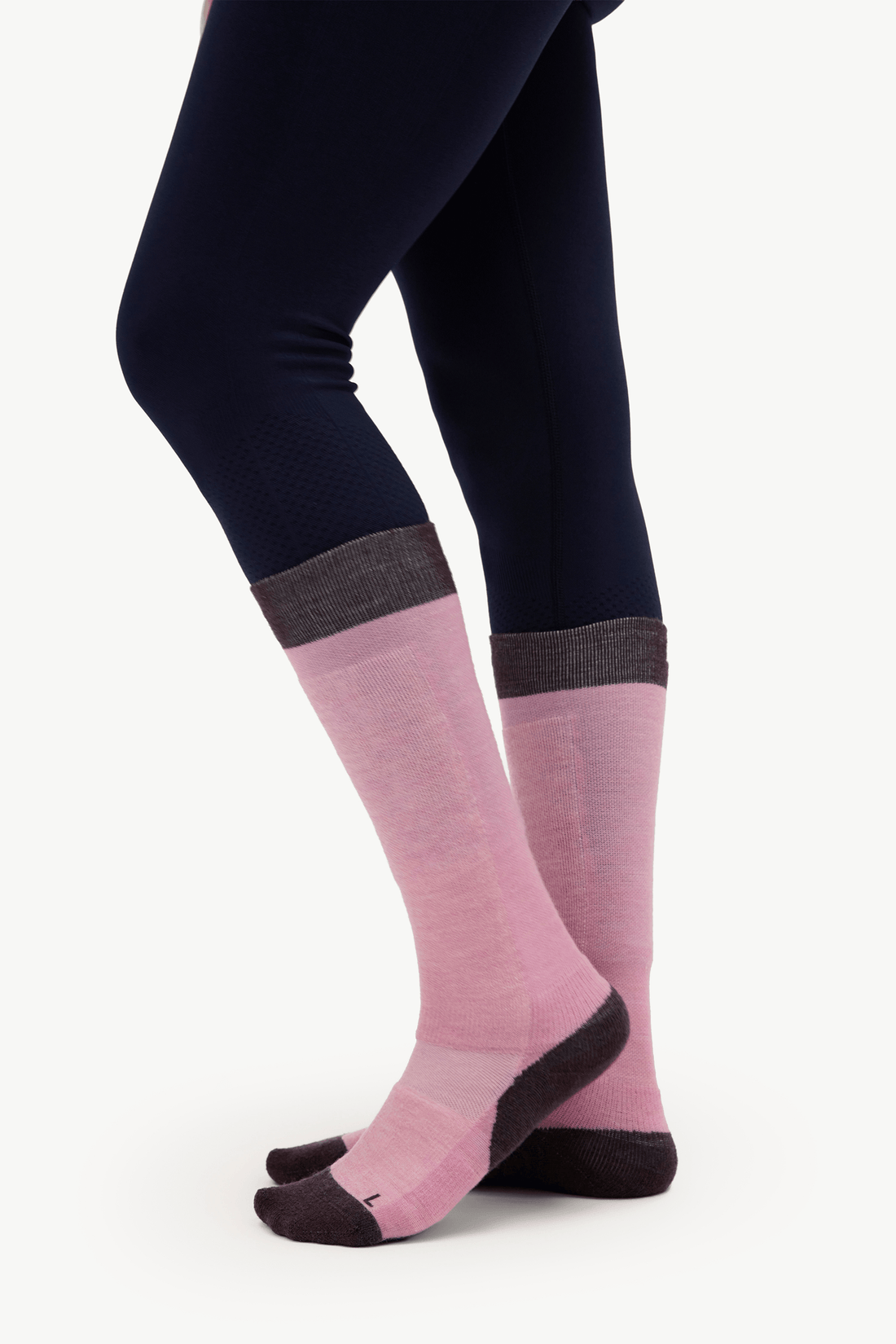 A person wearing dark navy leggings and pink crew socks with dark gray ribbed cuffs and dark toe/heel sections, shown against a plain light background.