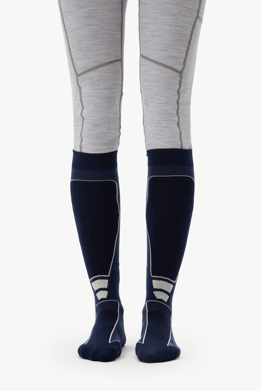 A pair of navy blue knee-high compression socks with light gray and white paneling, worn with light gray heathered leggings on a model's legs, shown against a plain white background.