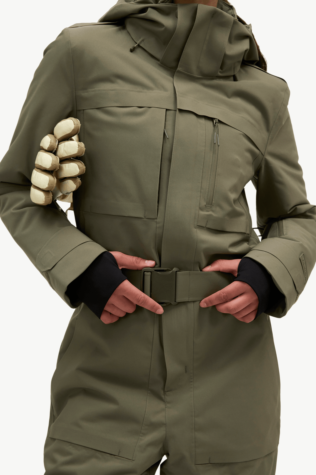 An olive green technical snowboard jacket with a unique integrated handlebar grip on the left sleeve, worn by a model against a clean white background.