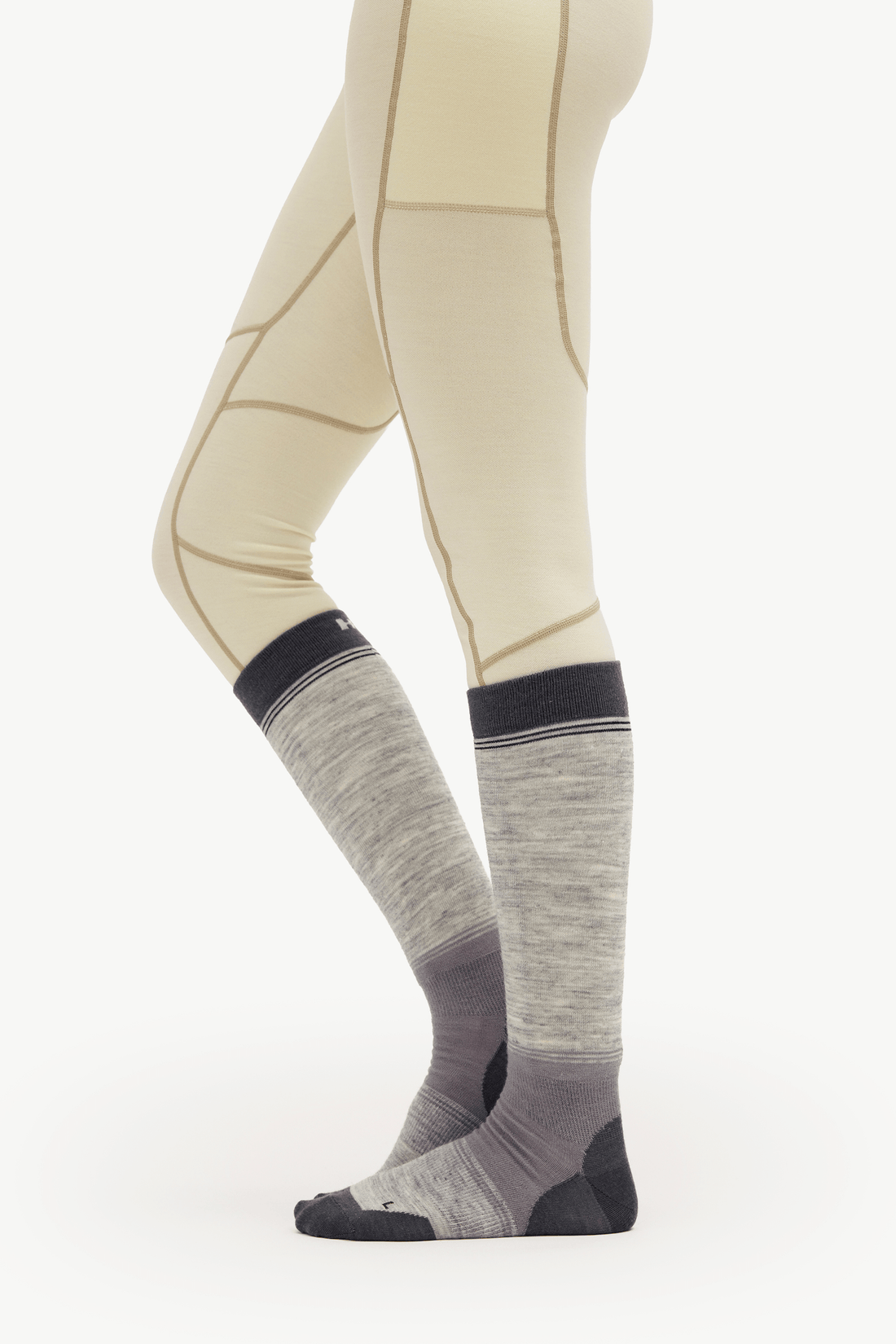 A person wearing knee-high athletic socks in heather gray with dark gray and black toe, heel, and cuff sections, shown against a plain light background.